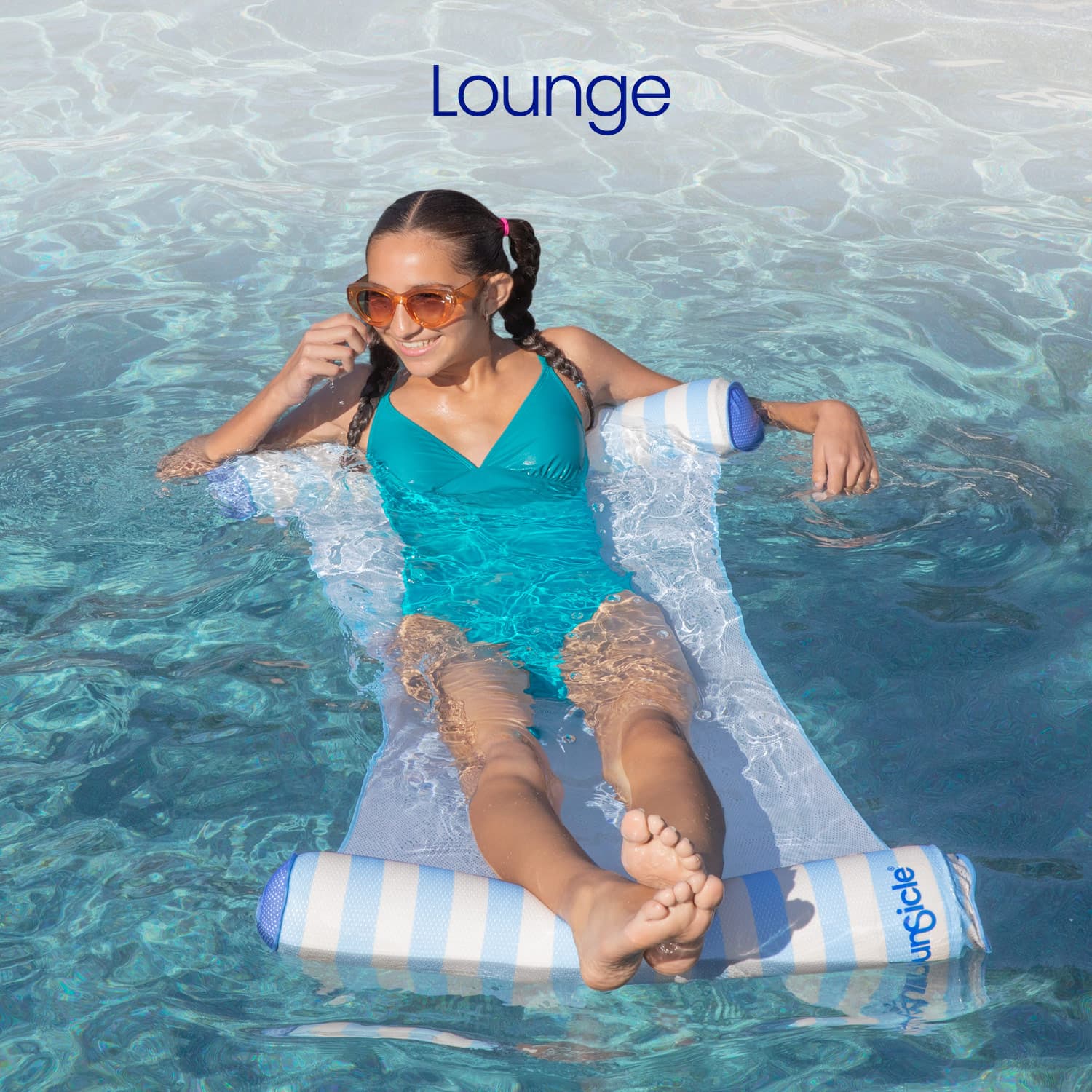 Woman relaxing on a striped pool float in clear blue water with 'Lounge' branding.