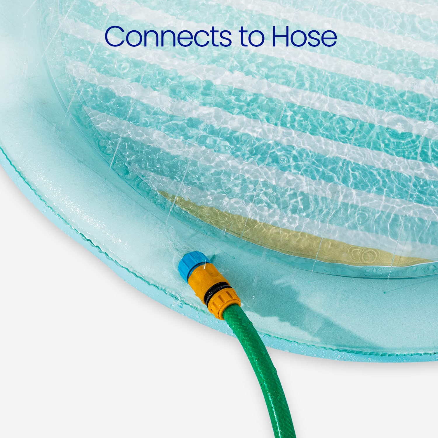 Close-up of a green garden hose with a blue and yellow connector attached to a transparent blue pool.