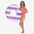 Woman holding a purple and white striped pool float with 'Funsicle' branding on a white background