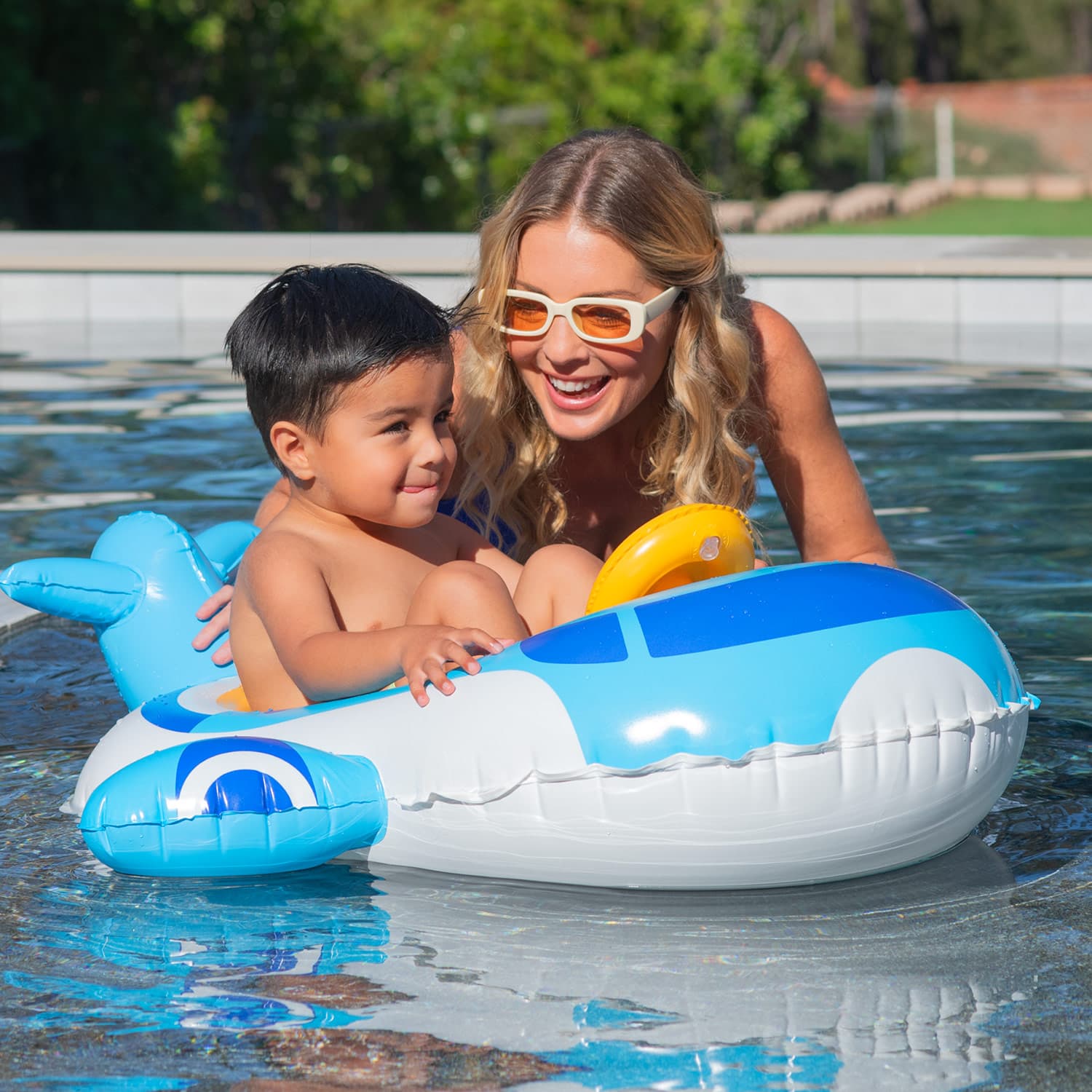 Woman and child in a pool with an airplane-shaped inflatable