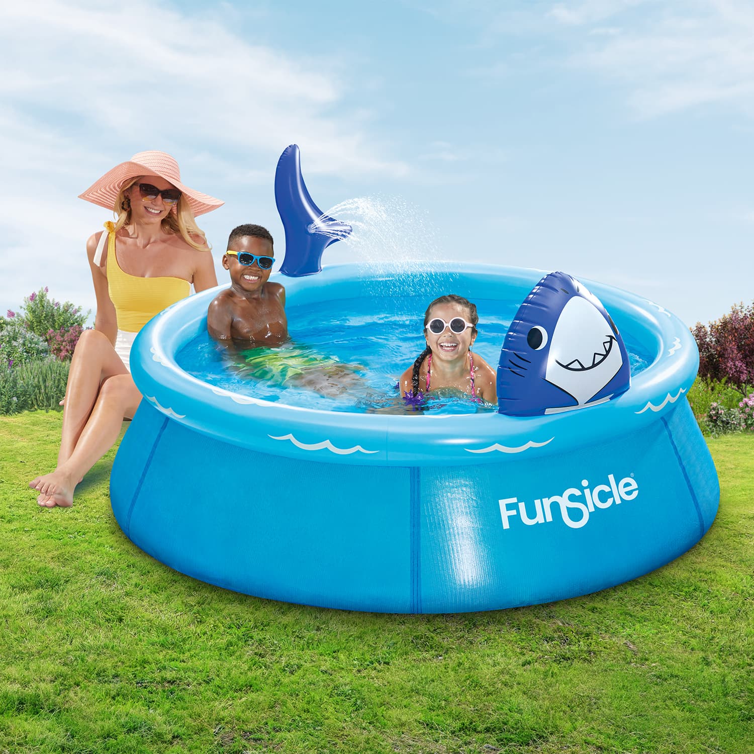 Children playing in a FunSicle inflatable pool with shark design on a grassy area.